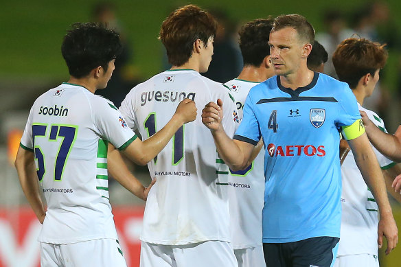 Sydney FC skipper Alex Wilkinson bumps fists with Lee Soobin of Jeonbuk Hyundai Motors before Wednesday night's AFC Champions League clash. The greeting was agreed by both clubs in lieu of the usual handshakes.