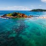 Aerial panorama of the tropical beach and clear sea with coral reefs in the town of Mirissa, Sri Lanka.
