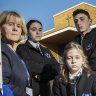 Alphington Grammar School principal Dr Vivianne Nikou stands with students Miles, Isabella, Ethan, Zoe and Nikoletta at the school gates. 