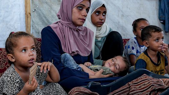 Displaced infant Abdel-Rahman Abu el-Jedian, now 11 months old, who suffers from polio, is cradled by his mother, at a makeshift camp in Deir al-Balah, central Gaza Strip on Tuesday.