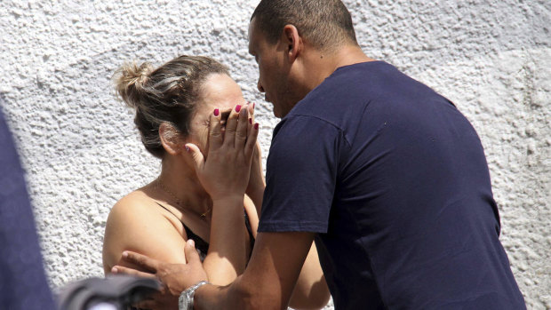 A man comforts a woman at the Raul Brasil State School in Suzano, Brazil, following the shooting. 