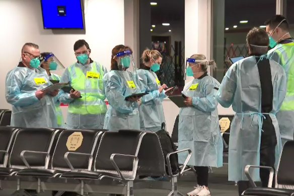 Authorised officers check the identification of passengers arriving at Melbourne Airport on Thursday. 