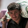 A Palestinian man carries food collected from a humanitarian aid distribution point. 
