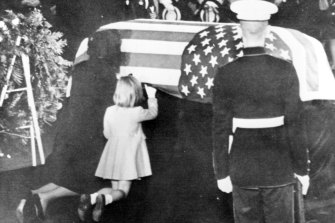Caroline Kennedy kneels next to her mother as Jacqueline kisses the casket of her husband, John F. Kennedy.
