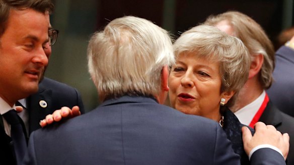 British Prime Minister Theresa May speaks with European Commission President Jean-Claude Juncker during a round table meeting at an EU summit in Brussels on Thursday.