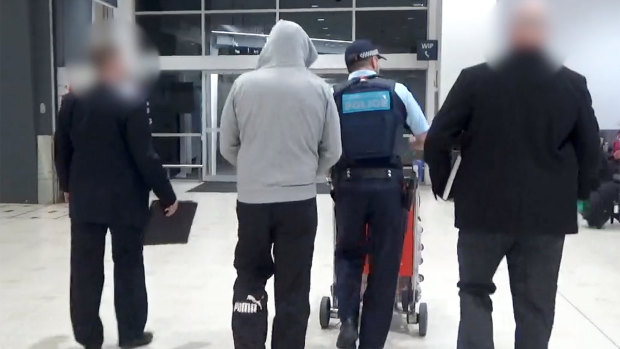 David Campbell arrives at Sydney Airport on Tuesday night, accompanied by Australian Federal Police officers.