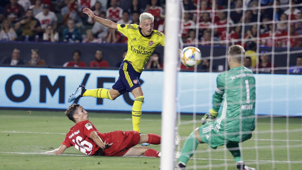 Target: Ozil fires the ball towards goalkeeper Manuel Neuer in the International Champions Cup match between Arsenal and Bayern Munich in July.