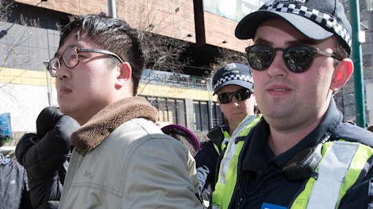 Police remove a Chinese nationalist from a Melbourne rally in support of Hong Kong democracy protesters.