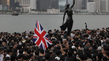 Thousands of protesters carrying the British flag march near the harbour of Hong Kong in 2019.