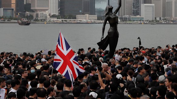 Thousands of protesters carrying the British flag march near the harbour of Hong Kong in 2019.