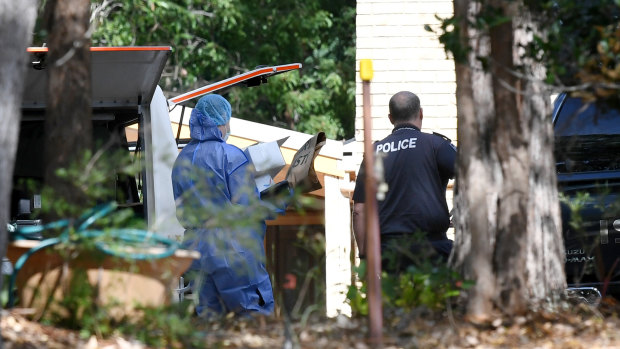 A police forensic officer (left) tends to the scene of the suspected double murder of Frank and Loris Puglia in Joyner in Brisbane's north, on Monday.