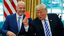 Donald Trump holds up a red card during a meeting with FIFA President Gianni Infantino in the Oval Office in 2018.