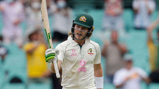 Will Pucovski waves his bat as he celebrates reaching 50 runs