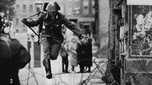 Making a dramatic bid for freedom this defecting East German soldier jumped a barbed wire barrier across the border between East and West Berlin.