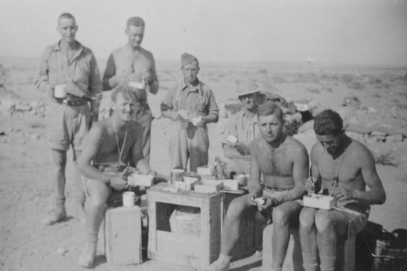 Lieutenant John Rosel (seated left) and the Rats of 2/24 Battalion snatch time for lunch outside Tobruk.