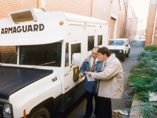 Police examine the abandoned Armaguard van after the 1994 armed robbery in Richmond.