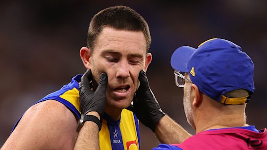 Eagles defender Jeremy McGovern is checked by the club doctor after a collision with the Demons’ Harrison Petty in round eight.