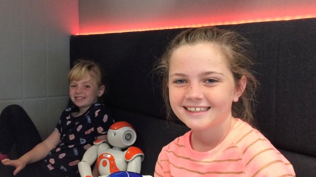Ella and older sister Ava, 11,  with two of the smaller robots at the centre.