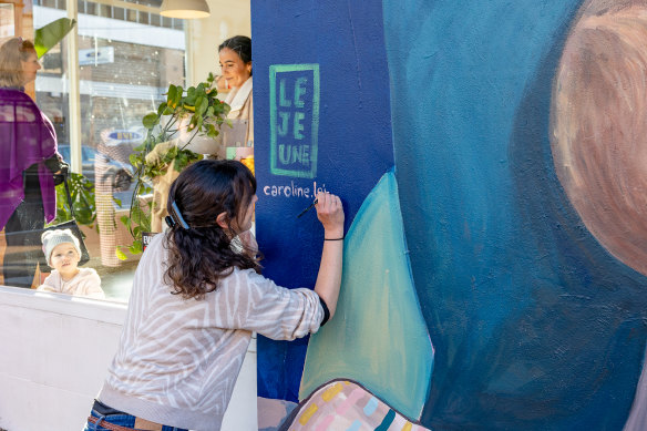 Caroline Lejeune adding the finishing touches to her mural in Collingwood.