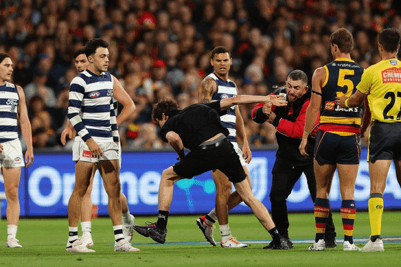 A man is dealt with after running onto Adelaide Oval as Geelong played Adelaide.