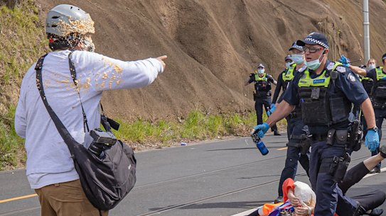 Age photographer Luis Ascui is pepper sprayed by a Victoria Police officer during the anti-lockdown protest in Richmond.