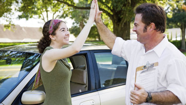 Driving tests will resume in NSW from July 1. Probably not a good idea to high-five your instructor after passing it like in this stock photo, however. 
