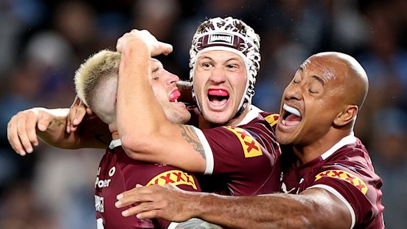 Queensland stars Cameron Munster, Kalyn Ponga and Felise Kaufusi celebrate their game-one win.