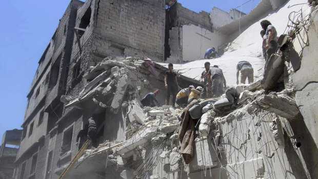 White Helmets inspect a damaged building after an air strike by Syrian government forces, in the town of Ariha, in the north-western province of Idlib.
