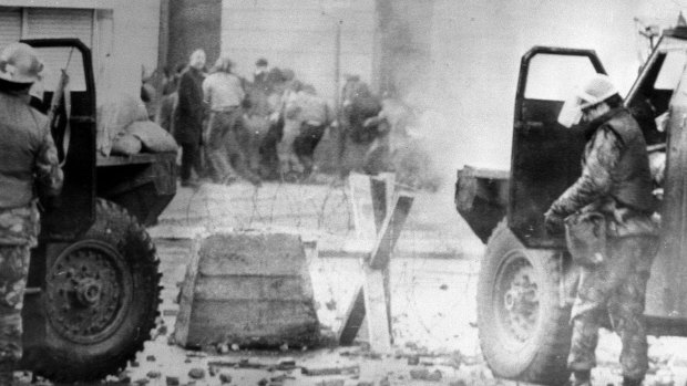 Soldiers take cover behind their armoured cars in Northern Ireland. in January 1972.