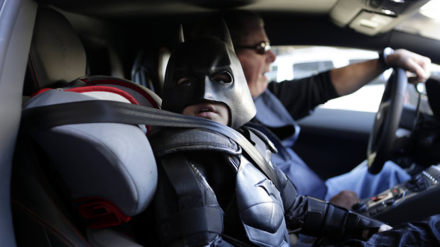 Miles Scott, 5, dressed as Batkid, waits in a Lamborghini "Batmobile" as he and Batman get ready to stop a make-believe bank robbery in San Francisco in 2013.