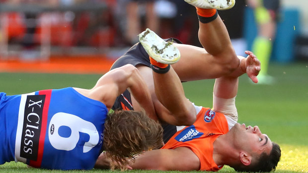 Grounded: Giant Tim Taranto is toppled by Bulldog Bailey Smith on Sunday.