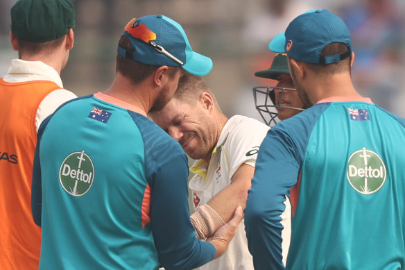 David Warner is examined by medical staff during the Delhi Test, where he suffered a hairline fracture of the elbow.