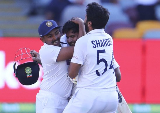 Indian players celebrate after defeating Australia by three wickets on the final day of the fourth cricket test at the Gabba.