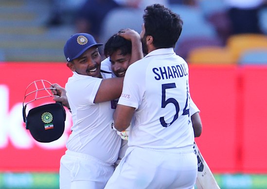 Indian players celebrate after defeating Australia by three wickets on the final day of the fourth cricket test at the Gabba.