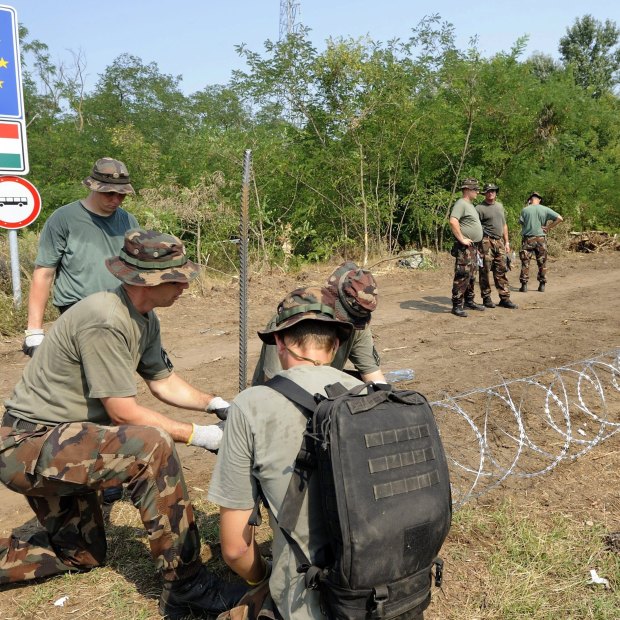 
Members of the Hungarian Defence Force erecting a border fence in 2015 to stem a wave of refugees.