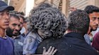 A Palestinian man carries a wounded child after an Israeli strike on a residential building in Gaza City on Friday.