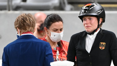 German coach Kim Raisner (centre) and rider Annika Schleu following the incident involving horse Saint-Boy at the Tokyo Olympics.