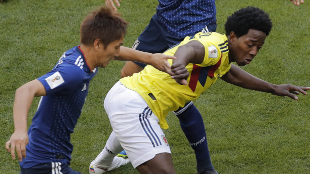 Tangle: Colombia's Carlos Sanchez in action moments before committing a handball in the box against Japan.