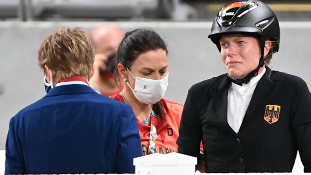 German coach Kim Raisner (centre) and rider Annika Schleu following the incident involving horse Saint Boy at the Tokyo Olympics.