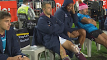 Luke Brooks sits on the Manly bench with ice on his knee.