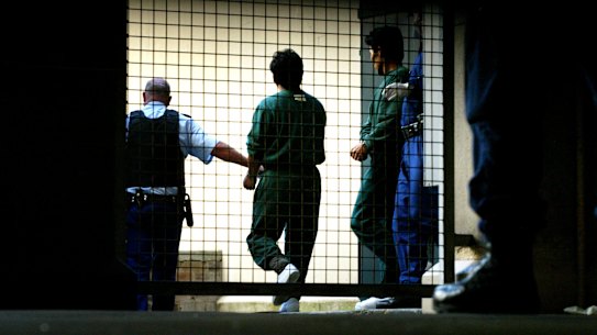 Pong Su crew members being escorted out of Sydney Central Local Court in 2003