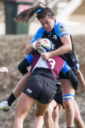 UC's Samantha Wood gets tackled by Queenslands Pleuni Kievit.
