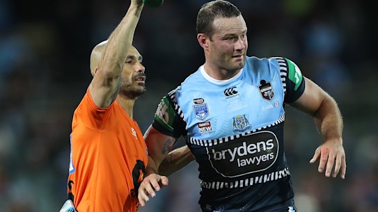 Boyd Cordner is helped from the field by Roosters and Blues trainer Travis Touma.