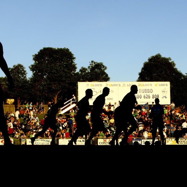 Raiders and Bulldogs players warm-up before a pre-season game at Dubbo’s Apex Oval in 2010.