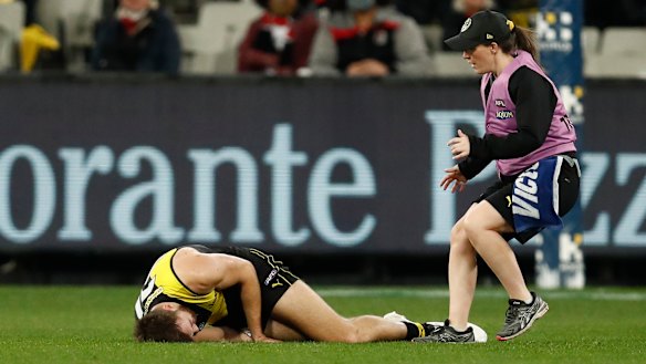 Noah Balta of the Tigers is helped by a trainer.