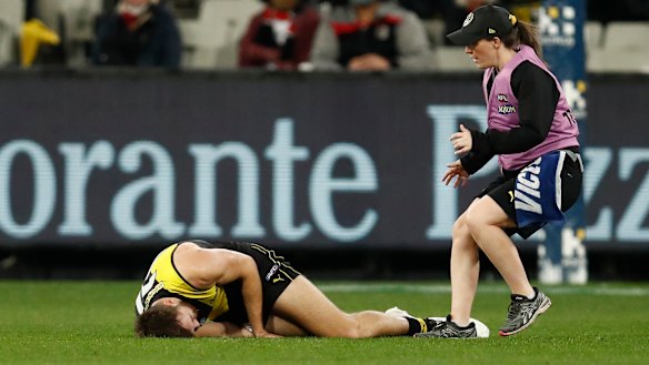 Noah Balta of the Tigers is helped by a trainer.