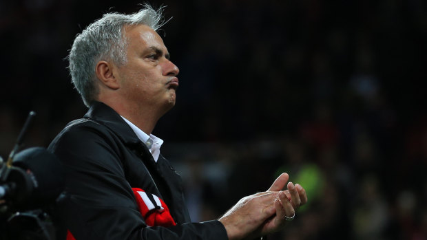 Defiant: Jose Mourinho stands on the touchline and applauds fans following the defeat to Tottenham.