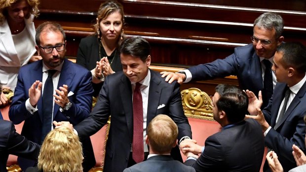 Italian Prime Minister Giuseppe Conte, centre, is congratulated at the end of his resignation address to the Senate in Rome.