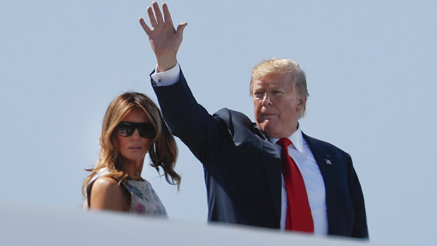 President Donald Trump, right, waves as he and first lady Melania Trump board Air Force One bound for Florida.