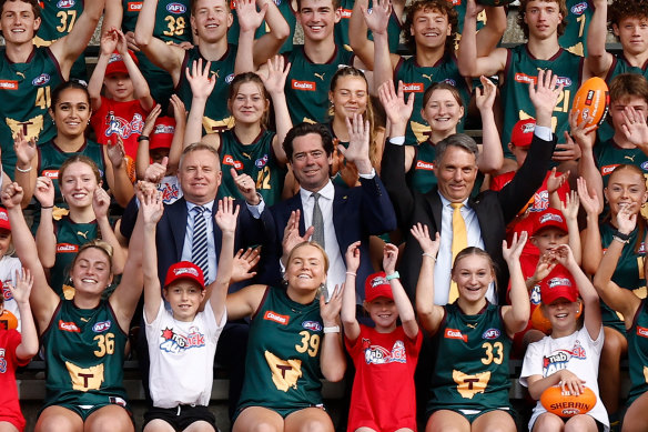 Tasmanian Premier Jeremy Rockliff, AFL CEO Gillon McLachlan and Acting Prime Minister Richard Marles are surrounded by local footballers for the announcement that Tasmania will get its own AFL team.